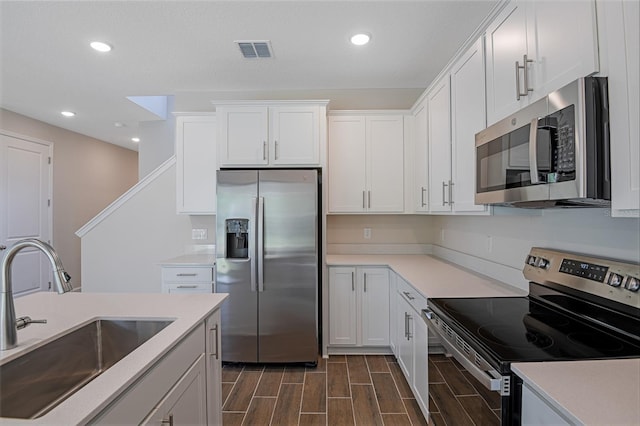 565 Summit River Dr, Apopka, FL 32712 - kitchen with appliances with stainless steel finishes, a sink, recessed lighting, white cabinetry, and light countertops
