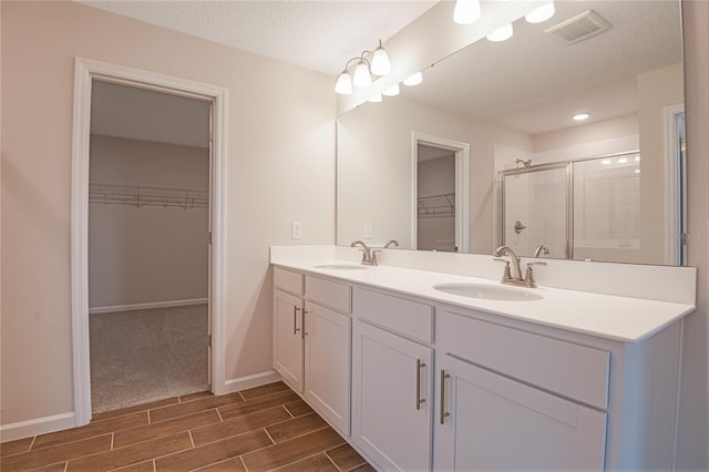 565 Summit River Dr, Apopka, FL 32712 - bathroom with a spacious closet, double vanity, wood tiled floors, a stall shower, and baseboards