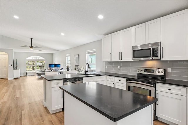 2700 Palm Isle Way, Orlando, FL 32829 - kitchen featuring stainless steel appliances, a sink, a peninsula, open floor plan, and white cabinetry