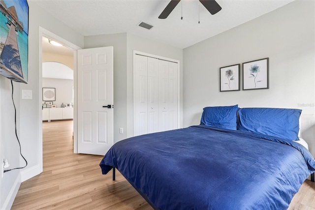 2700 Palm Isle Way, Orlando, FL 32829 - bedroom with light wood-type flooring, arched walkways, baseboards, a closet, and ceiling fan