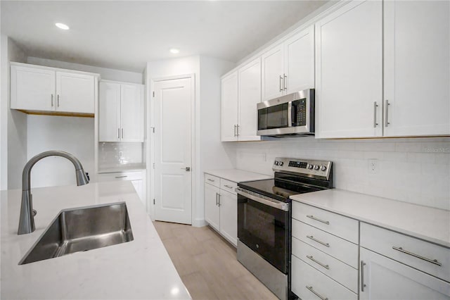 9127 Players Dr, Weeki Wachee, FL 34613 - kitchen with stainless steel appliances, white cabinets, decorative backsplash, light countertops, and recessed lighting