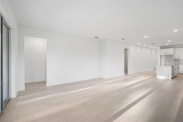 9127 Players Dr, Weeki Wachee, FL 34613 - unfurnished living room featuring recessed lighting and light wood-type flooring