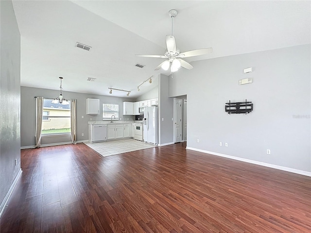 350 Scrub Jay Way, Davenport, FL 33896 - unfurnished living room with lofted ceiling, wood finished floors, a ceiling fan, a sink, and baseboards