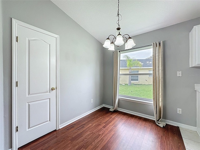 350 Scrub Jay Way, Davenport, FL 33896 - unfurnished dining area with a chandelier, dark wood-type flooring, baseboards, and a textured ceiling