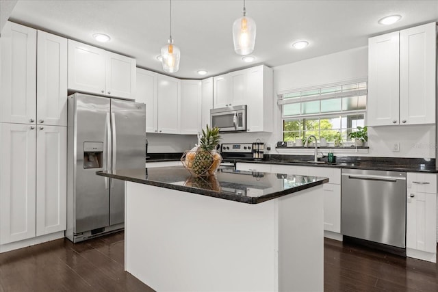 736 Forest Glen Ct, Maitland, FL 32751 - kitchen featuring appliances with stainless steel finishes, dark wood finished floors, white cabinetry, decorative light fixtures, and a center island
