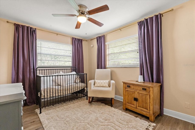 736 Forest Glen Ct, Maitland, FL 32751 - bedroom with multiple windows, wood finished floors, a crib, and a ceiling fan