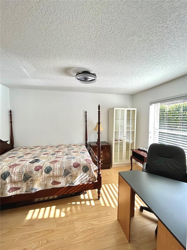 1084 Aspri Way, Riviera Beach, FL 33418 - bedroom with a desk, a textured ceiling, and light wood-type flooring