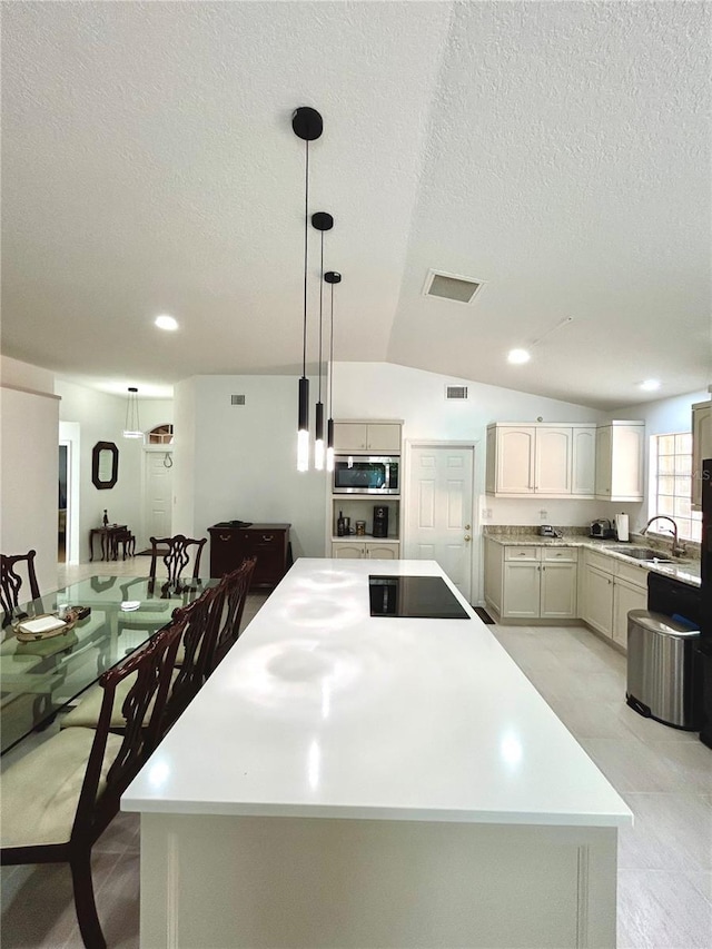 1084 Aspri Way, Riviera Beach, FL 33418 - kitchen featuring stainless steel microwave, a sink, black electric cooktop, a kitchen island, and vaulted ceiling