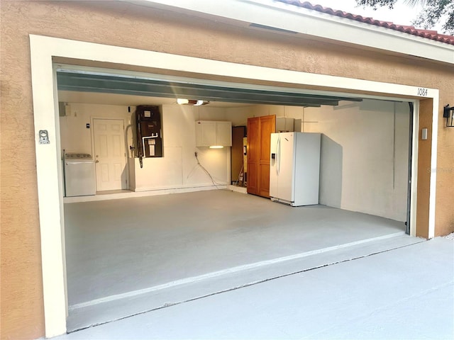 1084 Aspri Way, Riviera Beach, FL 33418 - garage featuring washer / dryer, white fridge with ice dispenser, and a textured wall