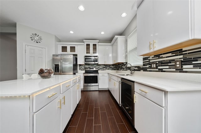 205 Lakeshore Dr, Davenport, FL 33837 - kitchen featuring stainless steel appliances, wine cooler, a sink, white cabinetry, and backsplash