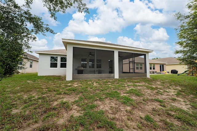 205 Lakeshore Dr, Davenport, FL 33837 - rear view of property with a sunroom, a ceiling fan, a yard, and stucco siding