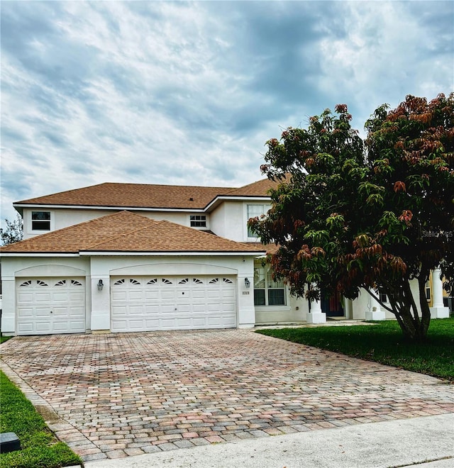 4368 Fox Glen Loop, Kissimmee, FL 34746 - view of front of home with decorative driveway, stucco siding, and an attached garage