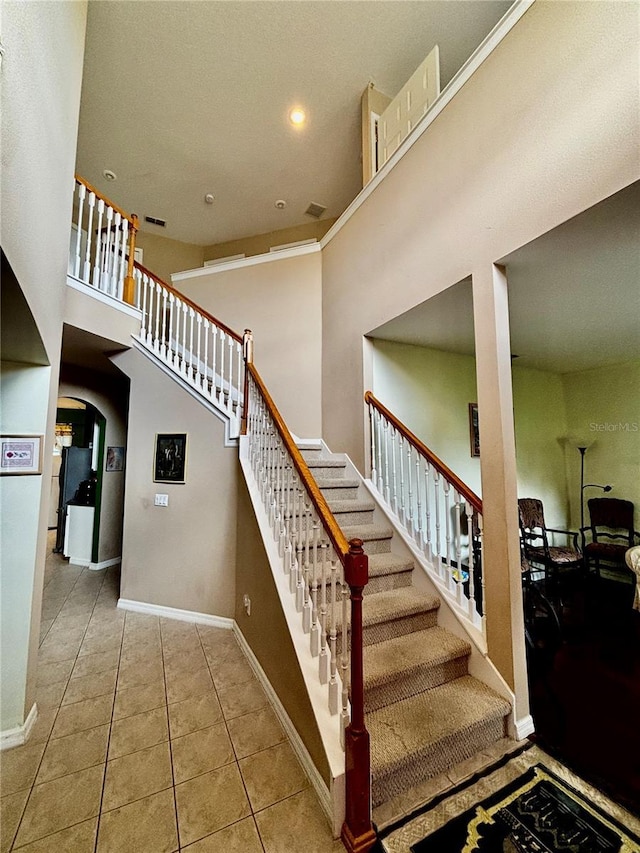 4368 Fox Glen Loop, Kissimmee, FL 34746 - stairs with arched walkways, tile patterned floors, a high ceiling, baseboards, and recessed lighting