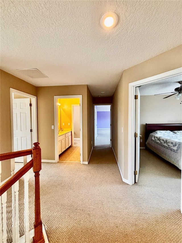 4368 Fox Glen Loop, Kissimmee, FL 34746 - hallway with light colored carpet, baseboards, and a textured ceiling