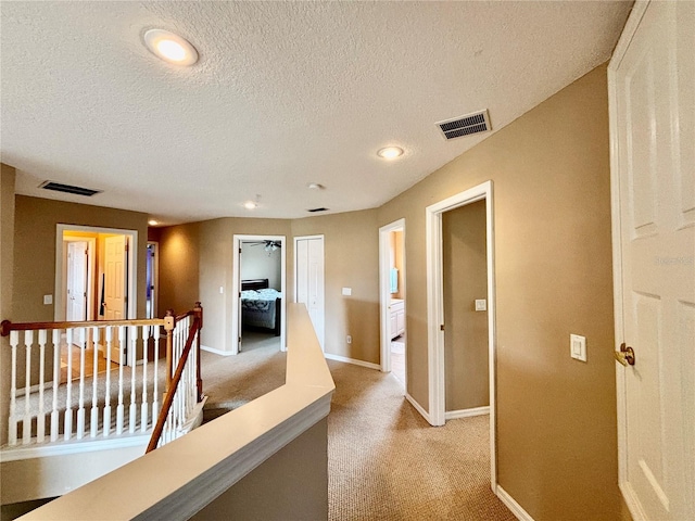 4368 Fox Glen Loop, Kissimmee, FL 34746 - hallway with an upstairs landing, baseboards, light colored carpet, a textured ceiling, and recessed lighting