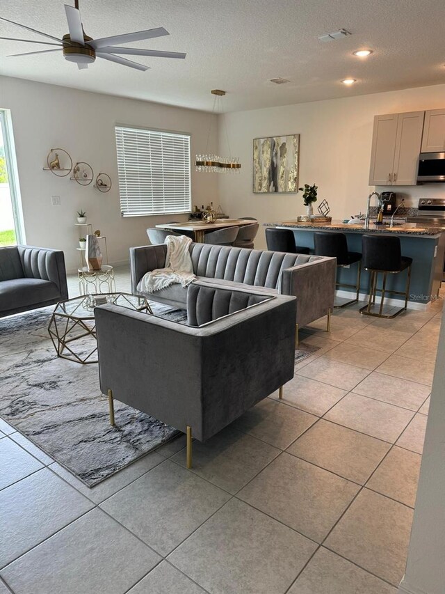 522 Feltrim Manor Rd, Haines City, FL 33844 - living room featuring a textured ceiling, a ceiling fan, and light tile patterned floors