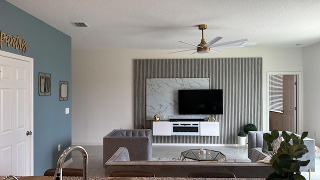 522 Feltrim Manor Rd, Haines City, FL 33844 - living area with tile patterned floors, a ceiling fan, a textured ceiling, and baseboards