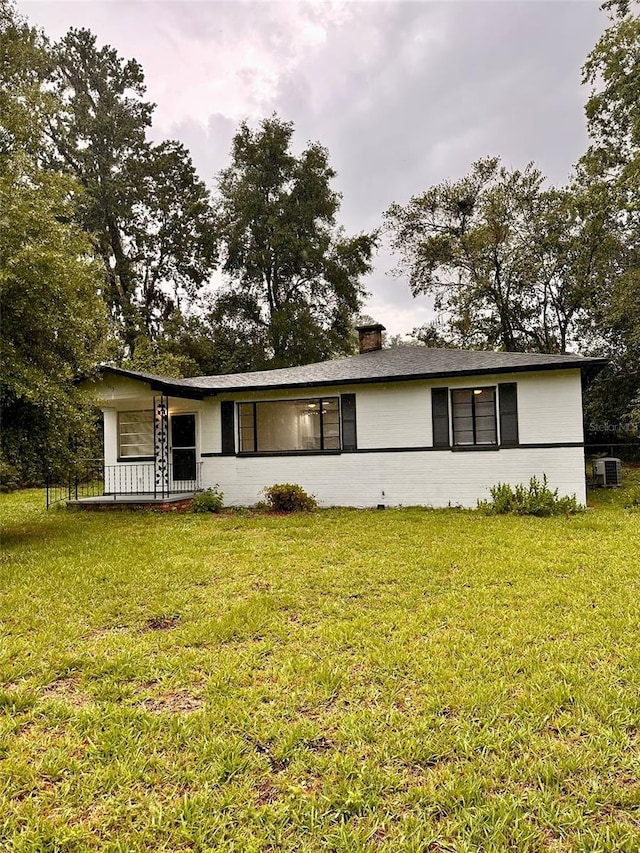 1615 NE 9th St, Ocala, FL 34470 - view of front of property with a front lawn and a chimney