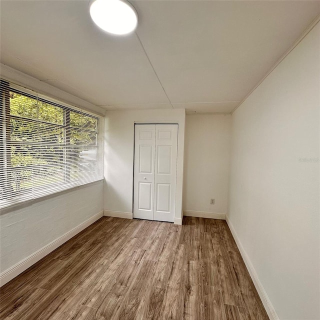 1615 NE 9th St, Ocala, FL 34470 - unfurnished bedroom featuring wood finished floors, baseboards, and a closet