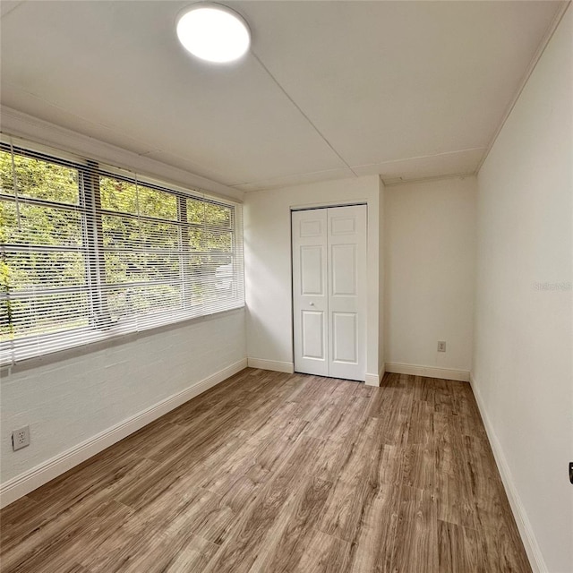 1615 NE 9th St, Ocala, FL 34470 - unfurnished bedroom with light wood-style floors, baseboards, and a closet