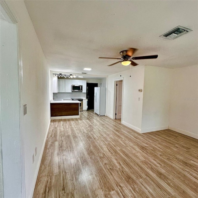 1615 NE 9th St, Ocala, FL 34470 - unfurnished living room with light wood-type flooring, baseboards, and a ceiling fan