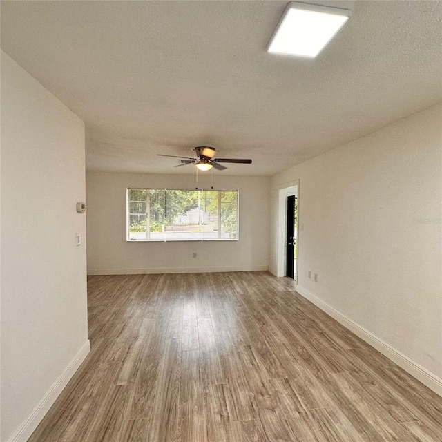 1615 NE 9th St, Ocala, FL 34470 - unfurnished room featuring wood finished floors, baseboards, a ceiling fan, and a textured ceiling