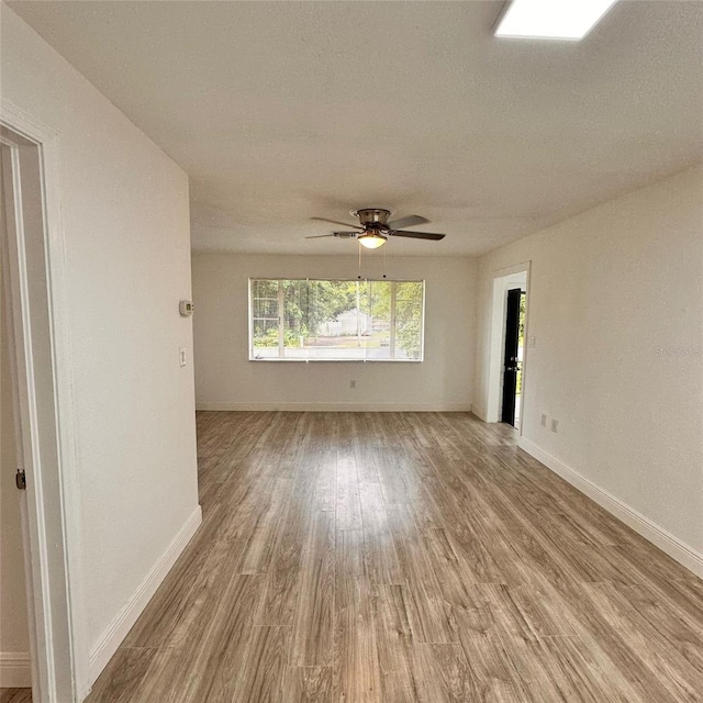 1615 NE 9th St, Ocala, FL 34470 - unfurnished room featuring wood finished floors, baseboards, ceiling fan, and a textured ceiling