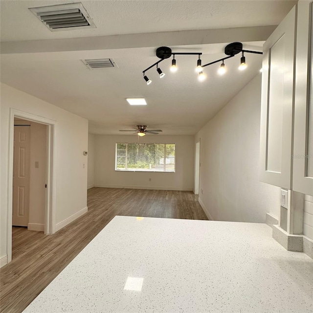 1615 NE 9th St, Ocala, FL 34470 - empty room with wood finished floors, rail lighting, baseboards, and ceiling fan
