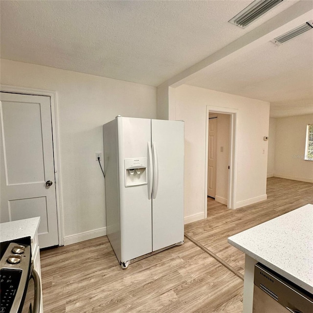 1615 NE 9th St, Ocala, FL 34470 - kitchen featuring white refrigerator with ice dispenser, black range oven, light wood-type flooring, a textured ceiling, and baseboards