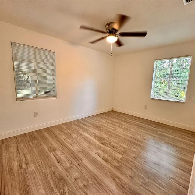 1615 NE 9th St, Ocala, FL 34470 - unfurnished room with wood finished floors, a ceiling fan, and baseboards