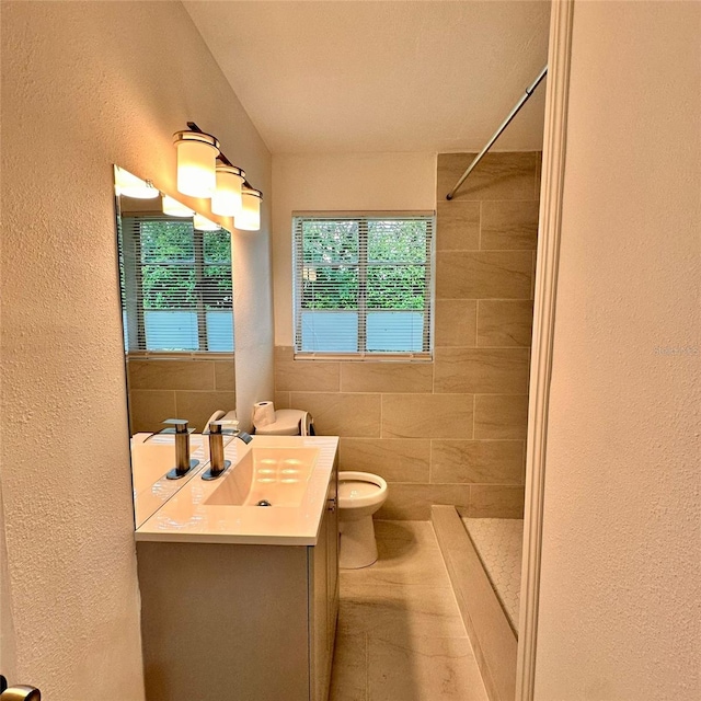1615 NE 9th St, Ocala, FL 34470 - full bathroom with toilet, a textured wall, a tile shower, and vanity