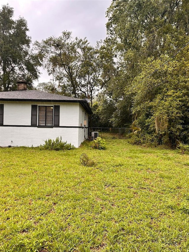 1615 NE 9th St, Ocala, FL 34470 - view of home's exterior featuring central AC unit and a chimney