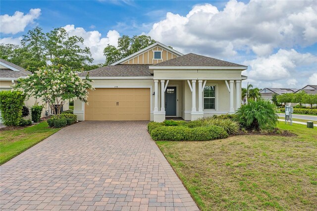1598 Whitewood Ct, Kissimmee, FL 34747 - view of front of home featuring a garage, stucco siding, decorative driveway, and a front lawn