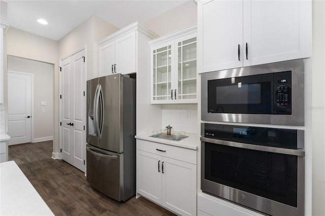 1598 Whitewood Ct, Kissimmee, FL 34747 - kitchen featuring appliances with stainless steel finishes, light countertops, dark wood-type flooring, white cabinetry, and recessed lighting