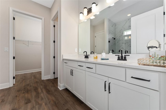 1598 Whitewood Ct, Kissimmee, FL 34747 - bathroom featuring a marble finish shower, double vanity, wood finished floors, baseboards, and a walk in closet