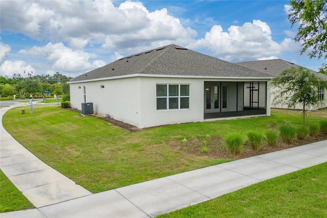 1598 Whitewood Ct, Kissimmee, FL 34747 - back of property featuring a yard, stucco siding, a shingled roof, and a sunroom