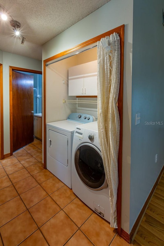 3267 Villa Way Cir, Saint Cloud, FL 34769 - laundry area featuring cabinet space, separate washer and dryer, a textured ceiling, and light tile patterned floors