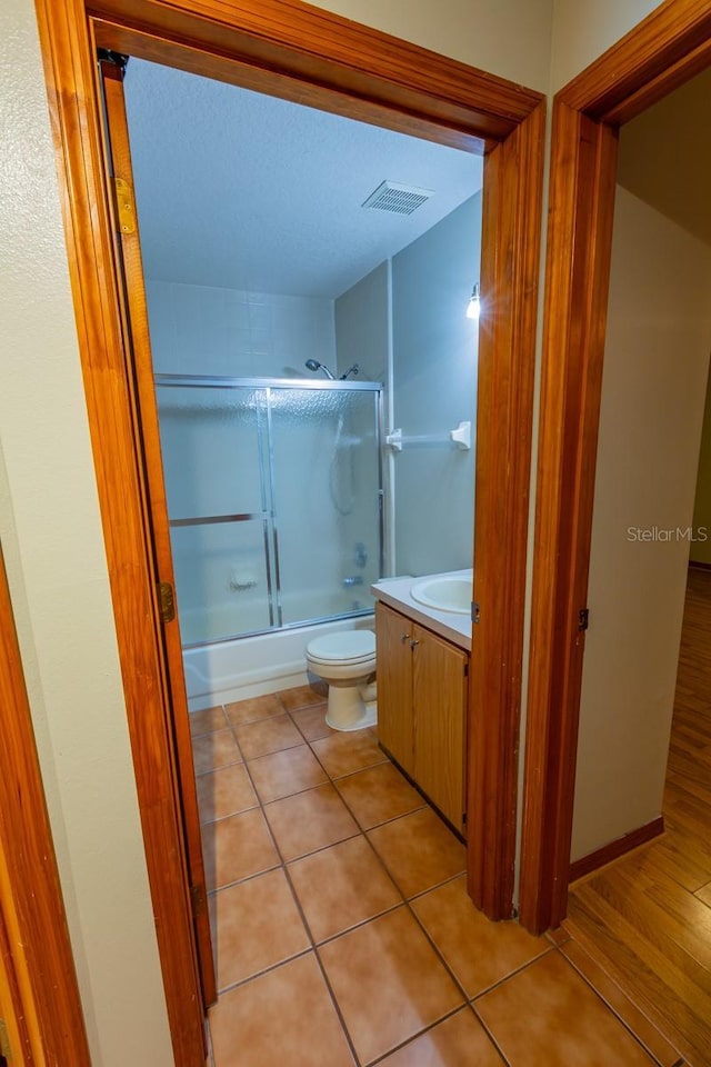 3267 Villa Way Cir, Saint Cloud, FL 34769 - bathroom with bath / shower combo with glass door, toilet, vanity, and tile patterned flooring