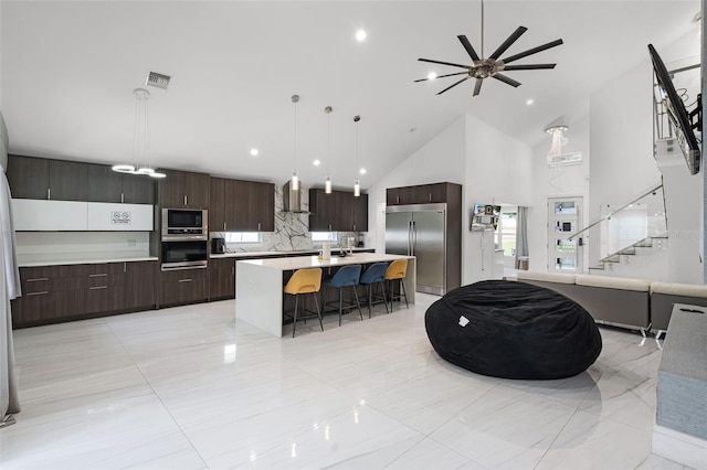 2561 Montego Bay Blvd, Kissimmee, FL 34746 - kitchen featuring built in appliances, wall chimney range hood, high vaulted ceiling, modern cabinets, and a breakfast bar area