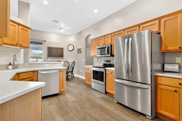 1822 Ashton Dr E, Saint Cloud, FL 34771 - kitchen featuring stainless steel appliances, light wood-style floors, light countertops, decorative backsplash, and recessed lighting