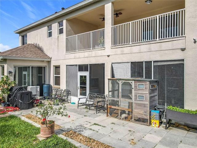 16072 Shasta St, Clermont, FL 34714 - rear view of house featuring a balcony, stucco siding, a patio area, and roof with shingles