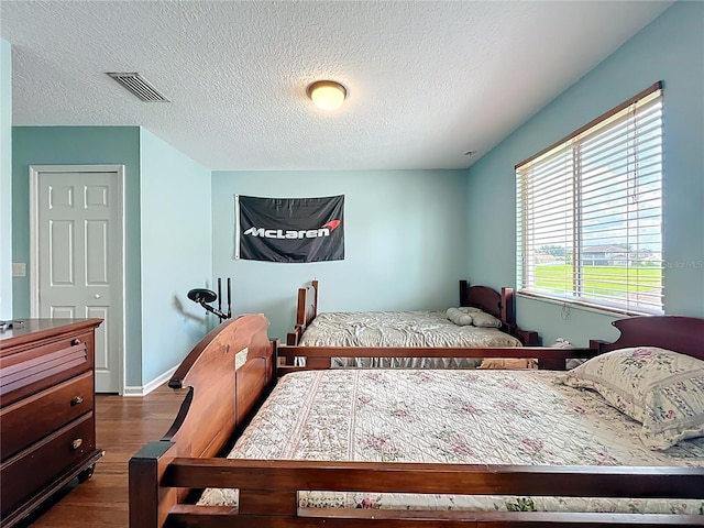 16072 Shasta St, Clermont, FL 34714 - bedroom with dark wood finished floors, a textured ceiling, and baseboards