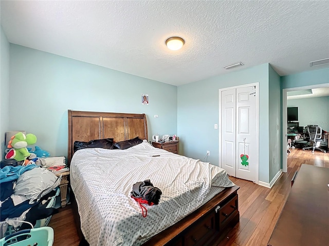 16072 Shasta St, Clermont, FL 34714 - bedroom featuring wood finished floors, a closet, a textured ceiling, and baseboards