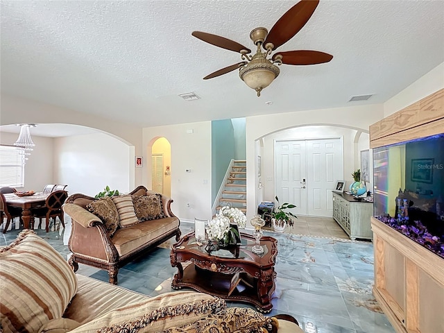 16072 Shasta St, Clermont, FL 34714 - living area with arched walkways, a ceiling fan, stairs, and a textured ceiling