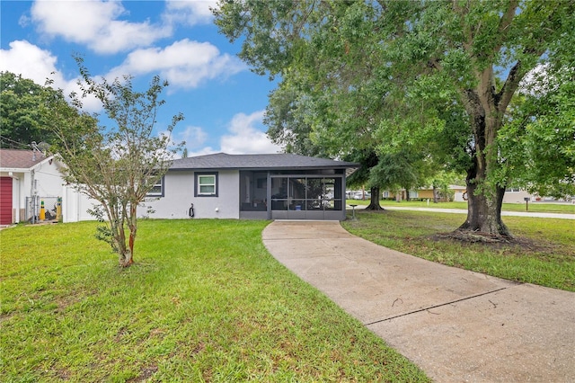2 S Lavon Ave, Kissimmee, FL 34741 - view of front of property featuring a sunroom, a front yard, stucco siding, and driveway
