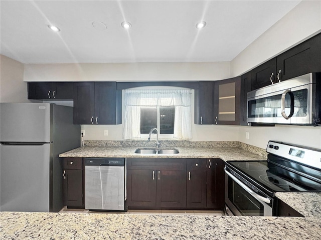 626 Orange Dr Unit 243, Altamonte Springs, FL 32701 - kitchen with stainless steel appliances, a sink, light stone counters, glass insert cabinets, and recessed lighting