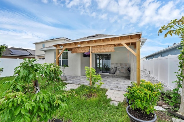 2838 Common Crane Ct, Harmony, FL 34773 - rear view of house with stucco siding, a patio area, and stone siding