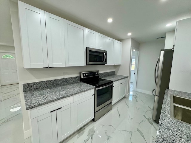 390 Hazel Cir, Punta Gorda, FL 33982 - kitchen featuring appliances with stainless steel finishes, light marble finish floors, recessed lighting, white cabinets, and baseboards