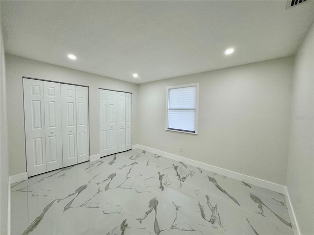 390 Hazel Cir, Punta Gorda, FL 33982 - unfurnished bedroom featuring baseboards, multiple closets, recessed lighting, and light marble finish floors