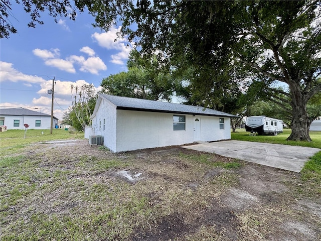 390 Hazel Cir, Punta Gorda, FL 33982 - rear view of house featuring central AC, a lawn, and stucco siding